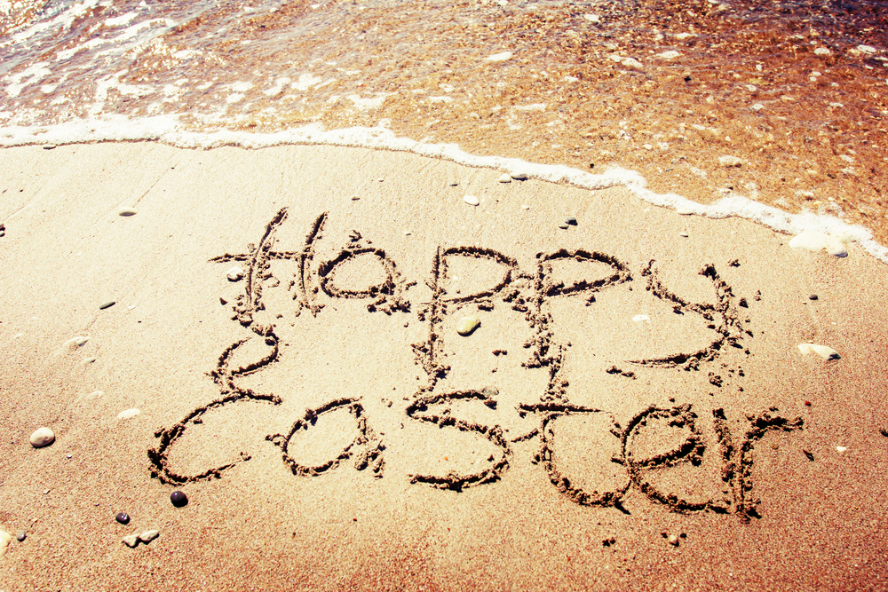Happy Easter written on a sandy beach